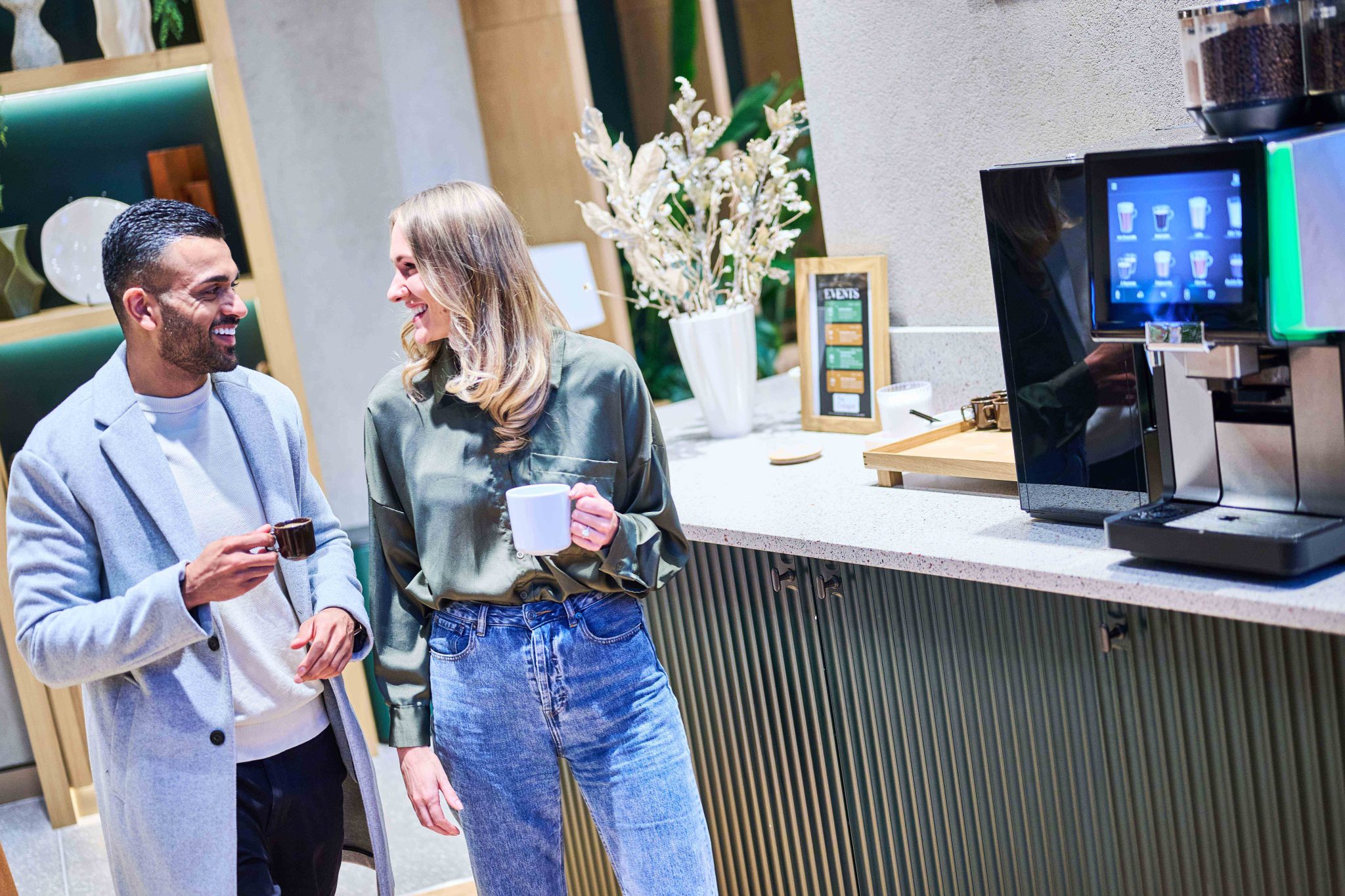 Residents enjoying coffee by the self-service machine in The Octagon lounge, showcasing premium amenities in Birmingham city centre luxury apartments