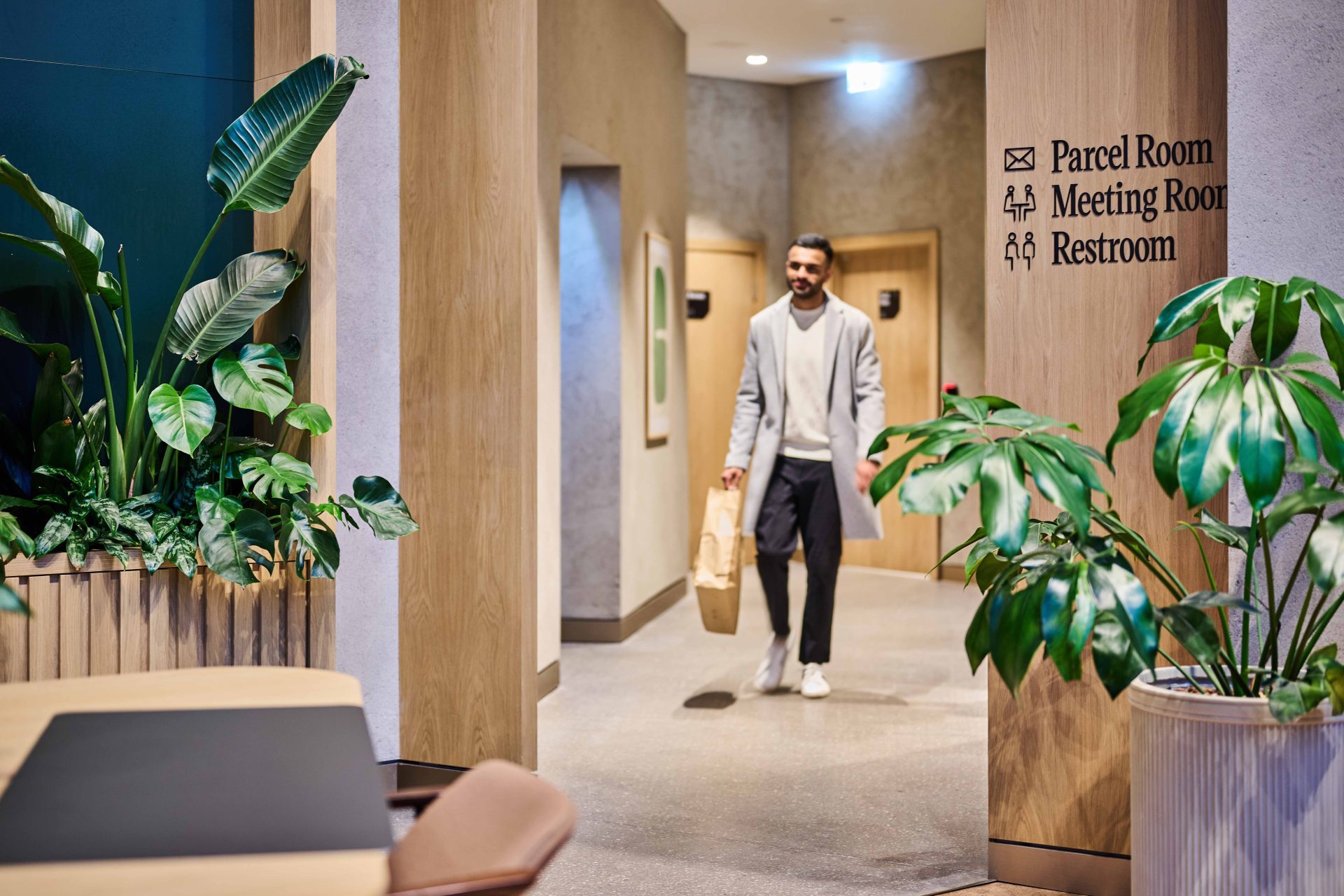 Male resident walking from the parcel room at The Octagon, highlighting secure delivery amenities in Birmingham luxury rental apartments